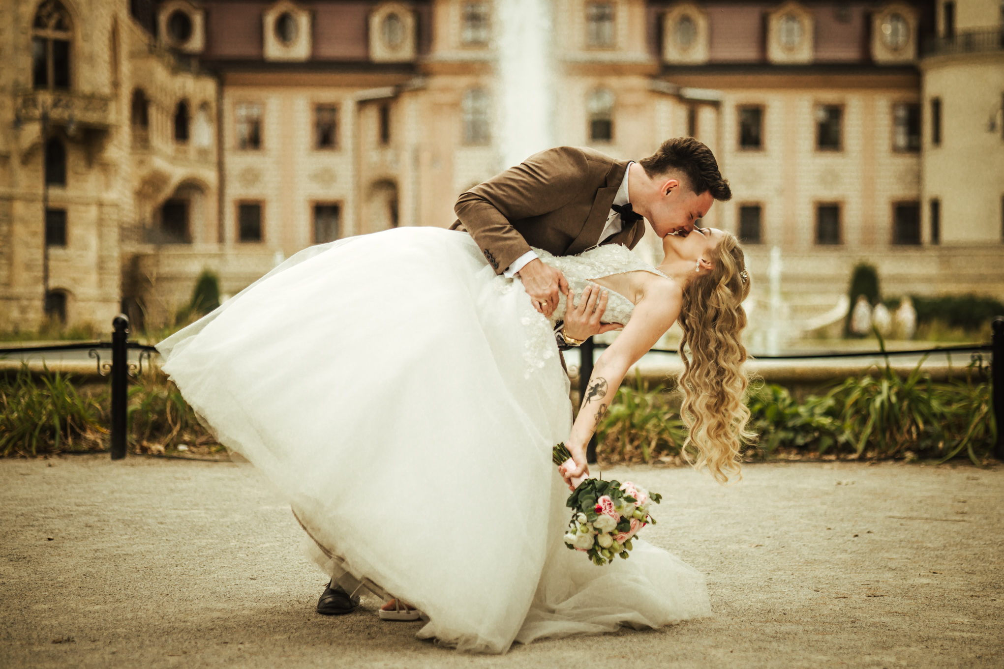 Patrycja i Bartek tulący się przy fontannie w ogrodach Zamku Moszna podczas sesji poślubnej