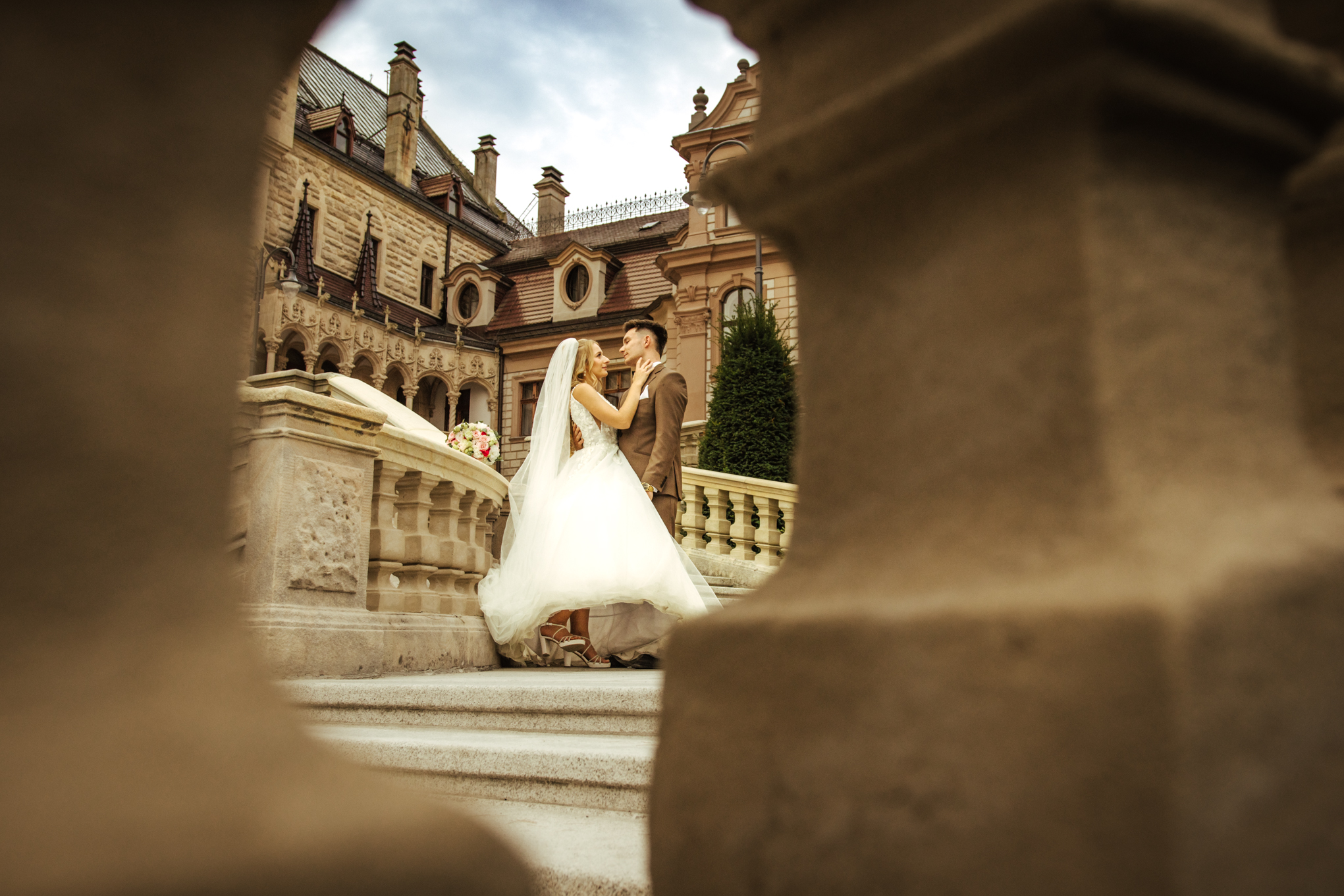 Emocjonalny moment Patrycji i Bartka przy schodach Zamku Moszna – reportaż poślubny