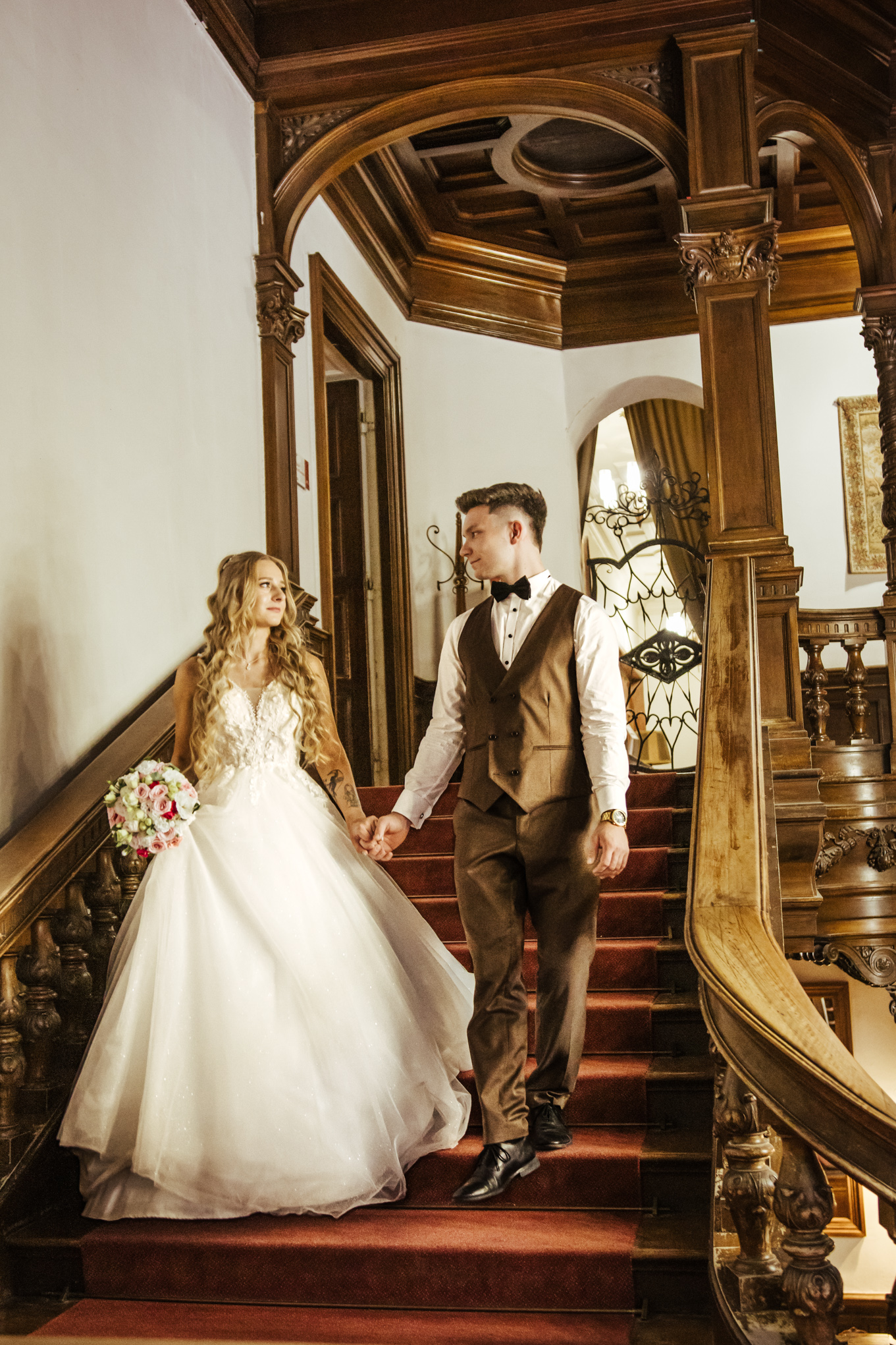 Patrycja i Bartek patrzą sobie głęboko w oczy schodząc po zabytkowych schodach