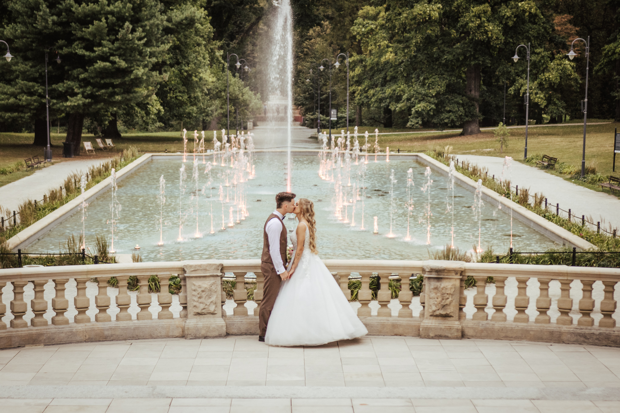 Pocałunek Pary Młodej na tle fontanny i parku w bajkowym Zamku Moszna 2025
