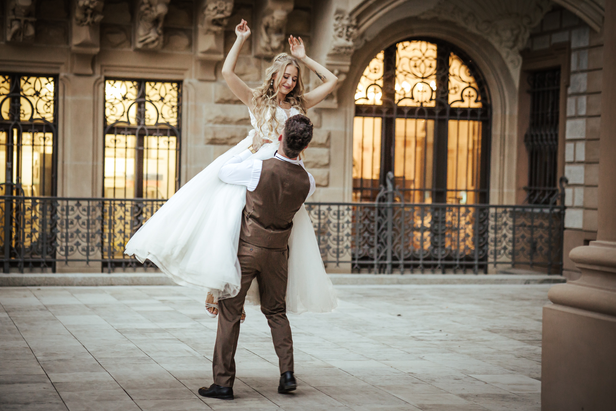 Tańcząca para na tle zamkowych krużganków – sesja poślubna w Mosznej