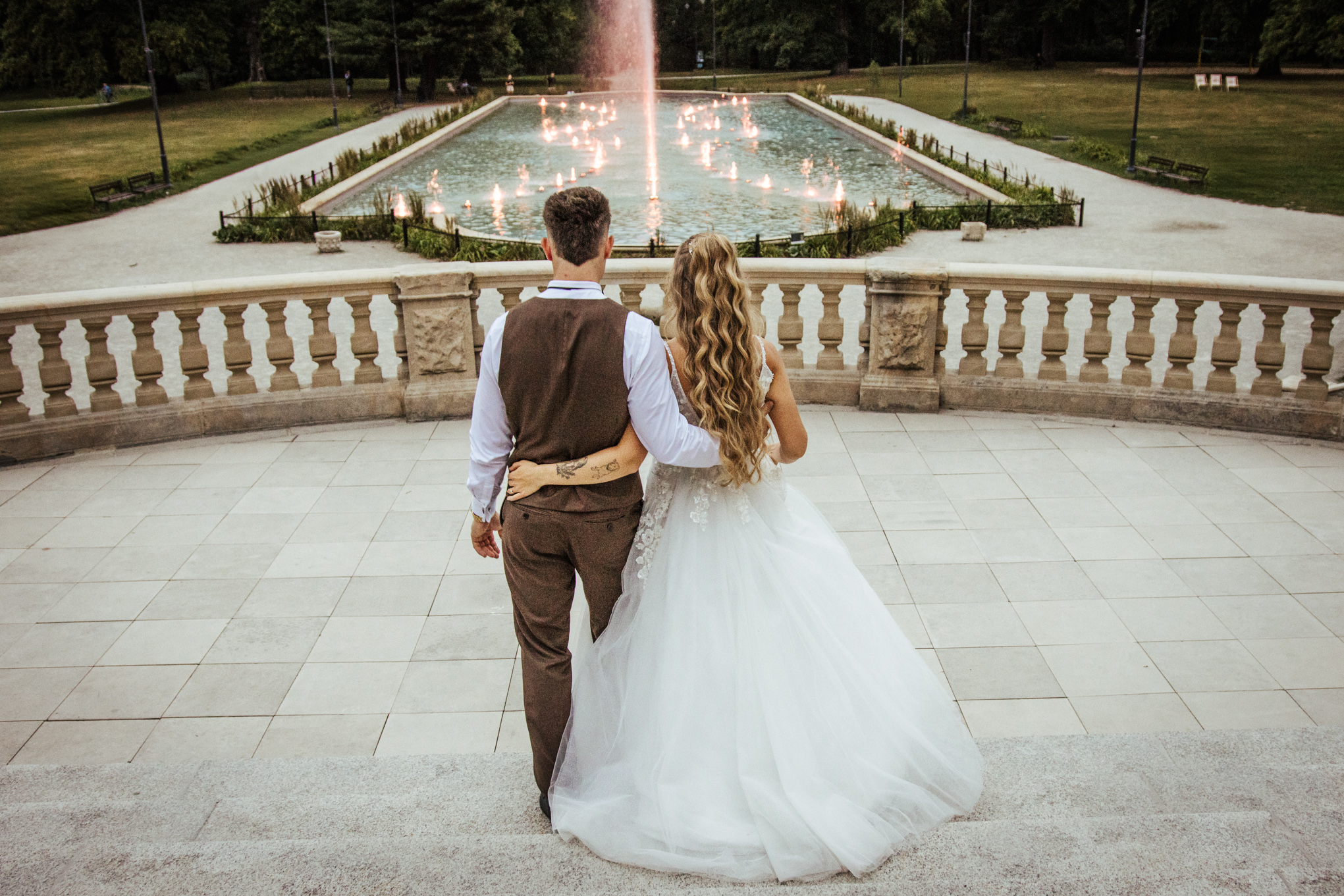 Patrycja i Bartek w objęciach przy rozświetlonej fontannie – sesja poślubna w parku Zamku Moszna